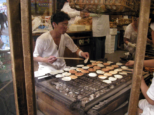 A Japanese guy making senbei at an old store