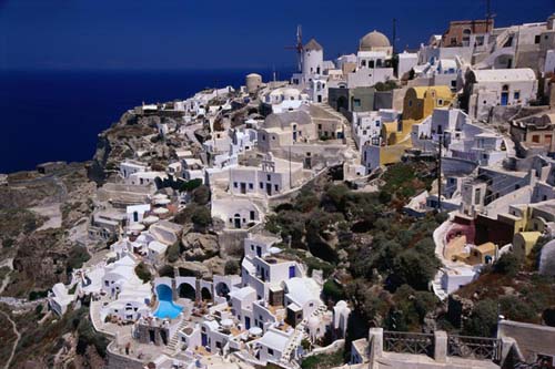 Southern Aegean village of Oia perched on Santorini crater rim.